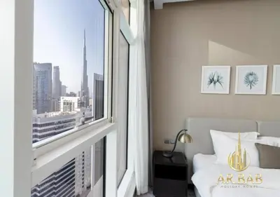 a bedroom with a window with a view of a city at Damac Maison Prive - Luxury Studio - Burj Khalifa View in Dubai