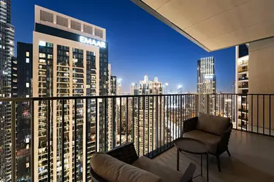 a balcony with a view of a city at night at FIRST CLASS 4BR Spacious Luxury Retreat in Dubai