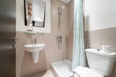 a bathroom with a toilet and a sink and a shower at FIRST CLASS 4BR Spacious Luxury Retreat in Dubai