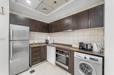 a kitchen with a refrigerator and a dishwasher at FIRST CLASS Studio Cozy Urban Retreat in Dubai