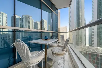a balcony with a table and chairs on a building at FIRST CLASS Studio Cozy Urban Retreat in Dubai