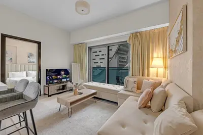 a living room with a couch and a tv at Lavish Apartment in Dubai in Dubai