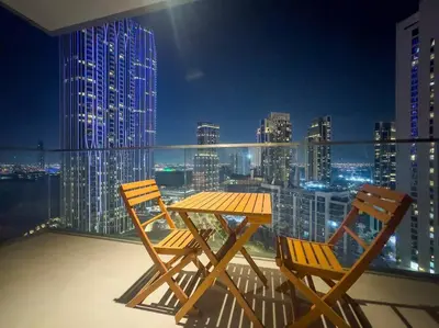 a table and two chairs on a balcony with a city skyline at FIRST CLASS Luxury 2BR in Creek Harbour Pool, Gym, Walk to Dining in Dubai