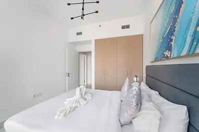 a bedroom with a white bed with pillows on it at FIRST CLASS Luxury 2BR in Creek Harbour Pool, Gym, Walk to Dining in Dubai