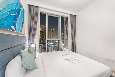 a bedroom with a white bed and a large window at FIRST CLASS Luxury 2BR in Creek Harbour Pool, Gym, Walk to Dining in Dubai