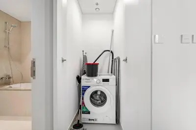 a washing machine in a bathroom next to a door at FIRST CLASS 1BR Urban Chic Oasis in Dubai