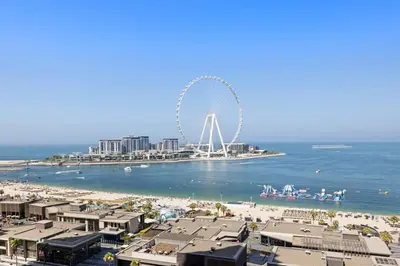 a view of a beach with a ferris wheel in the background at Full Sea View - Spacious & Newly Renovated Studio in JBR in Dubai