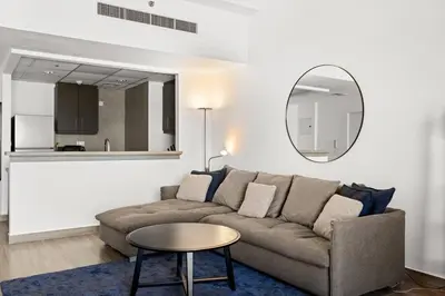 a living room with a couch and a round mirror at Full Sea View - Spacious & Newly Renovated Studio in JBR in Dubai