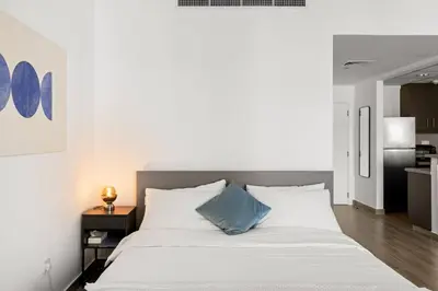 a bedroom with a white bed with a blue pillow at Full Sea View - Spacious & Newly Renovated Studio in JBR in Dubai