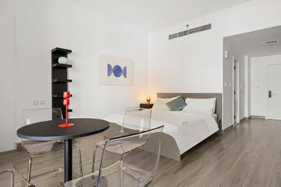 a bedroom with a bed and a table with chairs at Full Sea View - Spacious & Newly Renovated Studio in JBR in Dubai