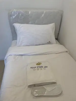 a white bed with two sheets and a tray on it at Four Stars Dubai Marina JBR in Dubai Marina