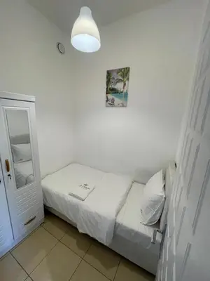 a small bedroom with a bed and a mirror at Four Stars Dubai Marina JBR in Dubai Marina