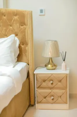 a bedroom with a bed and a nightstand with a lamp at 2BR - LUXE Serene Suite by Canal in Dubai