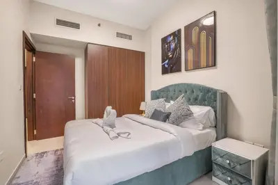 a bedroom with a large bed with a green headboard at 2BR - LUXE Serene Suite by Canal in Dubai