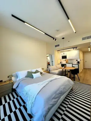 a bedroom with a large bed and a living room at Brand New Studio - Comfy & WFH in Dubai