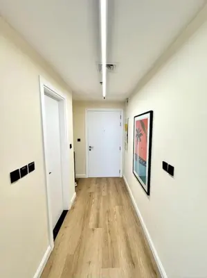 an empty room with a hallway with wood floors at Brand New Studio - Comfy & WFH in Dubai