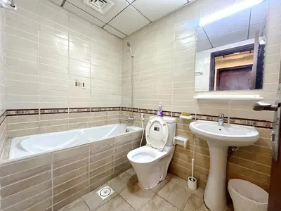 a bathroom with a tub and a toilet and a sink at Nomad Partition Room in Barsha Heights 3 mins to ICM Metro in Dubai