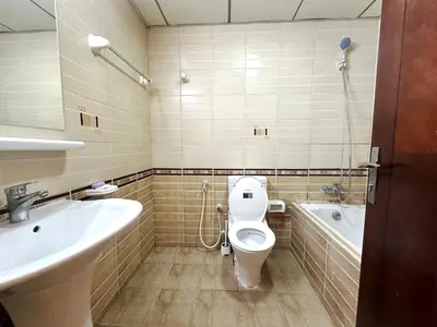 a bathroom with a toilet and a sink and a tub at Nomad Partition Room in Barsha Heights 3 mins to ICM Metro in Dubai