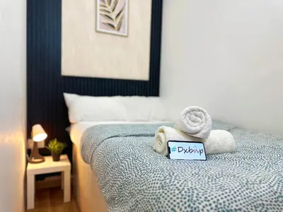 a room with a bed with towels and a sign on it at Nomad Partition Room in Barsha Heights 3 mins to ICM Metro in Dubai