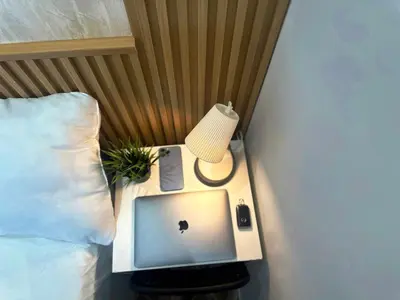 a bed with a desk with a laptop and a lamp at Quiet Partition Room in Tecom Barsha Heights in Dubai