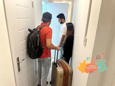 a group of people standing in a hallway with luggage at Quiet Partition Room in Tecom Barsha Heights in Dubai