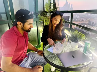 a man and a woman sitting at a table with a laptop at Horizon View Partition Room in Barsha Heights Near Metro in Dubai