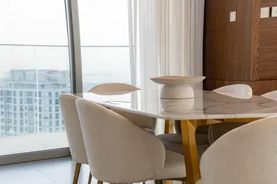a dining room table and chairs with a view of a city at Top-Notch 3BR in Stella Maris Tower in Dubai Marina in Dubai