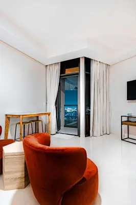 a living room with a orange chair and a television at High rise studio near Dubai Mall in Dubai