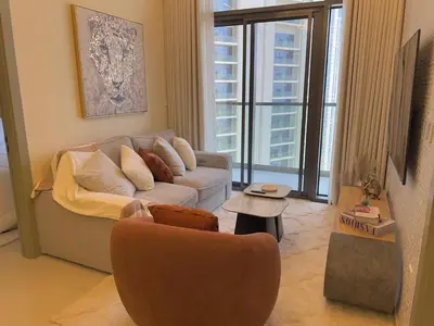 a living room with a couch and a chair at 2 bedroom in Downtown Dubai in Dubai