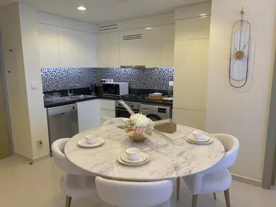 a kitchen with a table with two cups and chairs at 2 bedroom in Downtown Dubai in Dubai