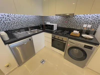 a kitchen with a washing machine and a sink at 2 bedroom in Downtown Dubai in Dubai