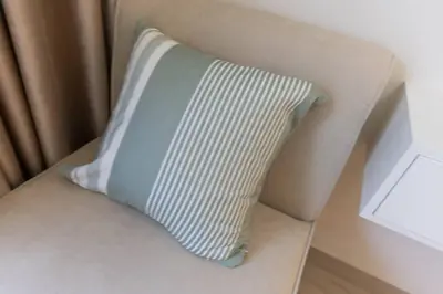 a blue and white pillow sitting on a chair at Cozy Studio in Azizi Riviera - Dubai in Dubai