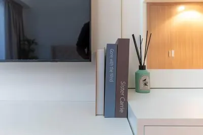 a book sitting on a counter next to a vase at Cozy Studio in Azizi Riviera - Dubai in Dubai