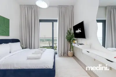 a bedroom with a king sized bed and a tv at Cozy Studio in Azizi Riviera - Dubai in Dubai