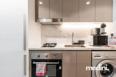 a kitchen with a stove top oven next to a sink at Cozy Studio in Azizi Riviera - Dubai in Dubai