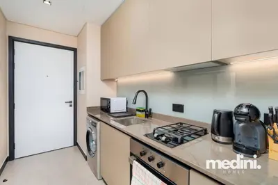 a kitchen with a sink and a stove top oven at 15th Northside - Studio - Dubai in Dubai
