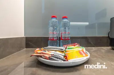 two bottles of water sitting on a plate with snacks at 15th Northside - Studio - Dubai in Dubai