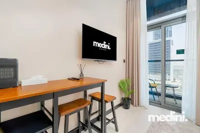 an office with a desk and a tv on a wall at 15th Northside - Studio - Dubai in Dubai