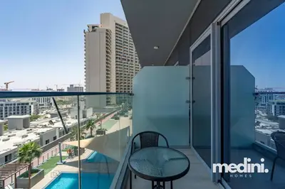 a balcony with a chair and a view of a city at Studio in Bloom Height - JVC - Dubai in Dubai