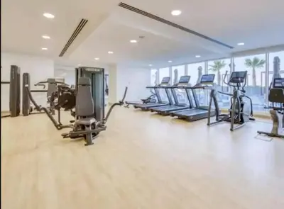a gym with rows of exercise bikes and treadmills at Studio in Bloom Height - JVC - Dubai in Dubai