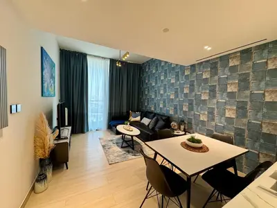 a living room with a couch and a table at Serene 1BR Haven with Pool View in Binghatti Corner! in Dubai