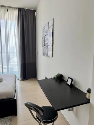 a black desk in a room with a bed and a chair at Serene 1BR Haven with Pool View in Binghatti Corner! in Dubai