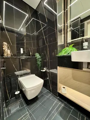 a bathroom with a white toilet and a sink at Serene 1BR Haven with Pool View in Binghatti Corner! in Dubai