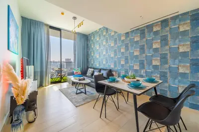 a living room with a table and chairs at Serene 1BR Haven with Pool View in Binghatti Corner! in Dubai