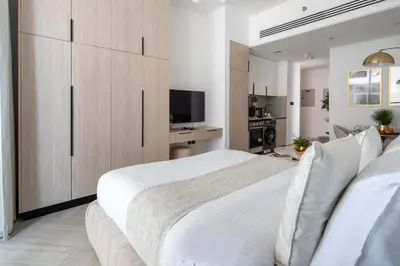 a bedroom with a large white bed and a television at Frank Porter - Empire Residences in Dubai