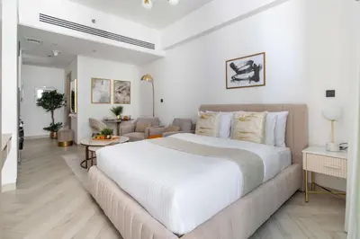a white bedroom with a large bed and a couch at Frank Porter - Empire Residences in Dubai