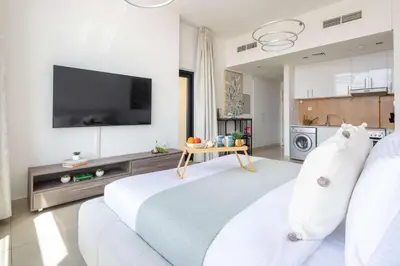 a living room with a large bed and a kitchen at Frank Porter - Square Tower in Dubai