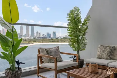 a balcony with two chairs and two potted plants at Luxury Palm with Billiard, PingPong table and Beach for 4 in Dubai
