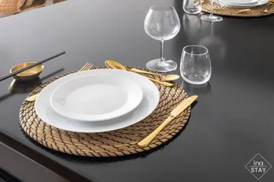 a table with a white plate and two wine glasses at Luxury Palm with Billiard, PingPong table and Beach for 4 in Dubai