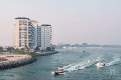 two boats in a river with buildings in the background at Luxury Palm with Billiard, PingPong table and Beach for 4 in Dubai